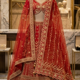 Crimson bridal lehenga on display with gold-bordered dupatta draped over shoulder.