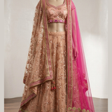 Blush peach bridal lehenga with hot pink dupatta, front view on display