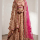 Bride in blush peach bridal lehenga with hot pink dupatta, front view