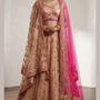 Bride in blush peach bridal lehenga with hot pink dupatta, front view