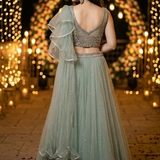 Dusty mint lehenga back view showing embellished blouse and ruffled dupatta