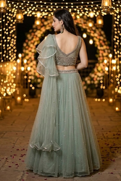 Dusty mint lehenga back view showing embellished blouse and ruffled dupatta
