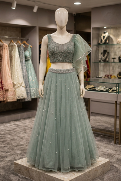 Dusty mint embellished lehenga, front view on display