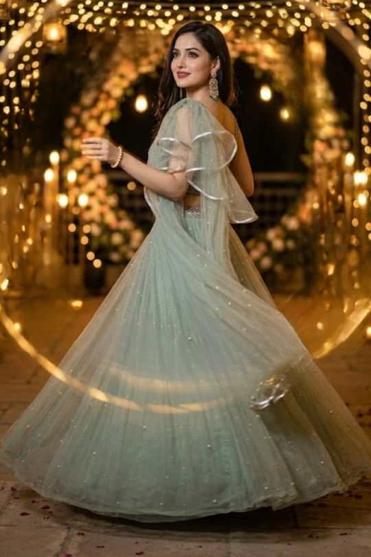 Woman twirling in dusty mint lehenga with flowing ruffled dupatta