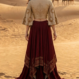 Woman in wine and beige fusion skirt set, standing in the desert with back pose