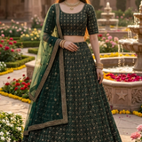 Woman in deep emerald green embroidered lehenga, garden courtyard backdrop