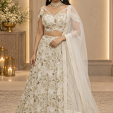 Bride in ivory gold sequin embroidered bridal lehenga with sheer dupatta, front view
