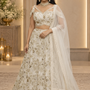 Bride in ivory gold sequin embroidered bridal lehenga with sheer dupatta, front view