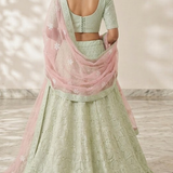 Mint green lehenga back view showing blouse design and pink dupatta