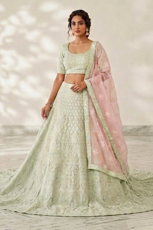 Woman in mint green lehenga with blush pink dupatta, white backdrop