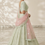 Mint green lehenga with blush pink dupatta, full length side pose