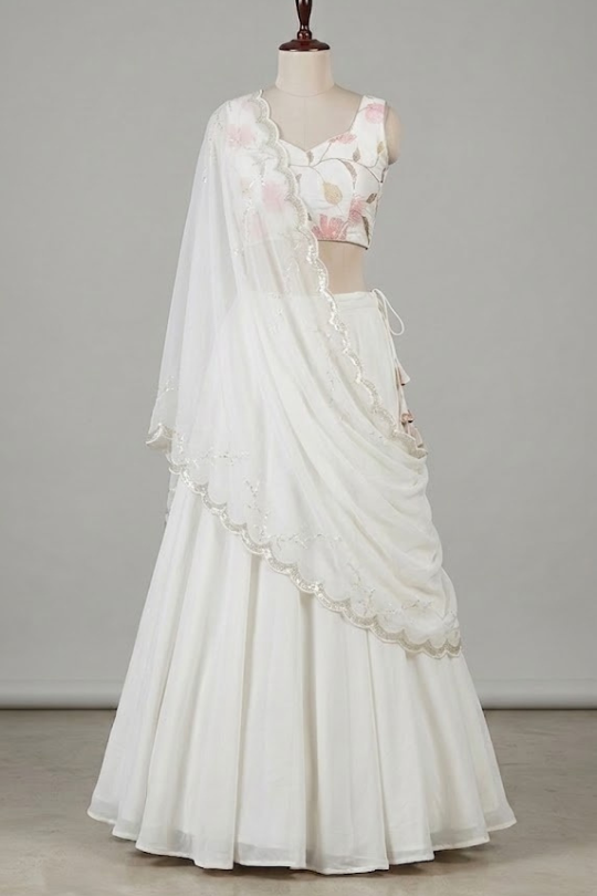 Close view of white floral lehenga fabric and lace-edged dupatta detailing