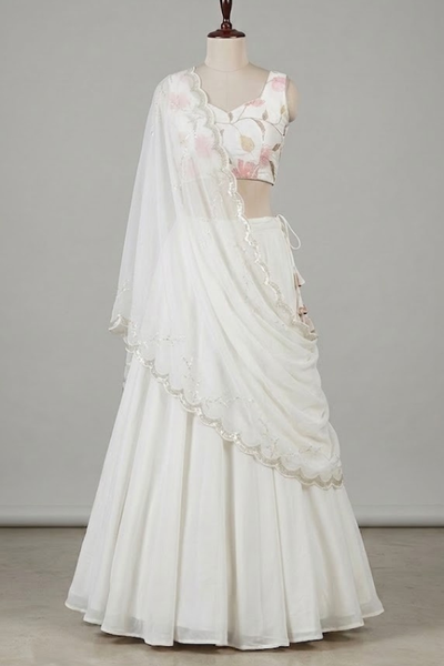 Close view of white floral lehenga fabric and lace-edged dupatta detailing