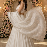 White lehenga side view showing flowing sheer dupatta with lace border