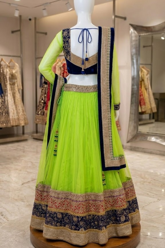 Neon lime lehenga back view on display showing navy embroidered blouse