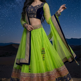 Woman in neon lime and navy blue designer lehenga, starry desert backdrop