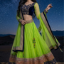 Woman in neon lime and navy blue designer lehenga, starry desert backdrop