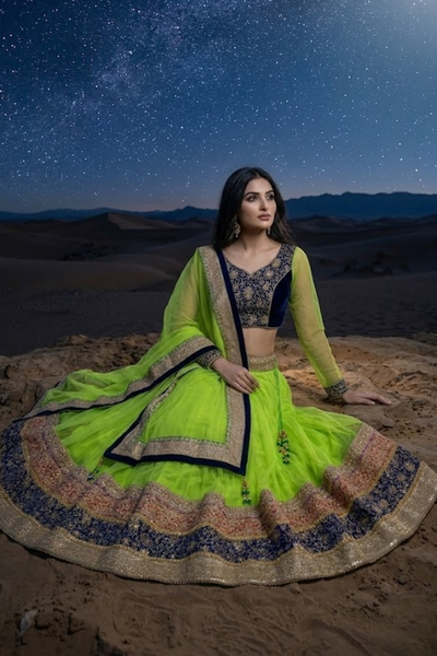 Model sitting wearing Neon lime and navy lehenga showing embroidered border