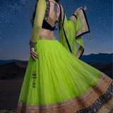 Woman twirling in neon lime lehenga with navy blue embroidered border