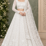 Bride in pearl white floral embroidered bridal lehenga with sheer dupatta, front view