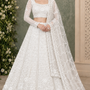 Bride in pearl white floral embroidered bridal lehenga with sheer dupatta, front view