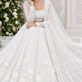 Pearl white bridal lehenga seated view showing floral embroidered skirt