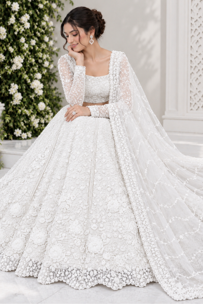Pearl white bridal lehenga seated view showing floral embroidered skirt