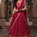 Bride in rani pink festive lehenga with golden zari embroidery, front view