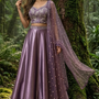 Woman in royal amethyst embroidered lehenga, forest backdrop