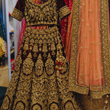 Maroon and peach bridal lehenga with gold embroidery, front view on display on hanger