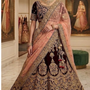 Bride in maroon and peach bridal lehenga with gold embroidery, front view