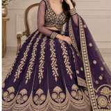 Bride seated in royal purple bridal lehenga showing golden embroidered skirt