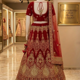 Red velvet bridal lehenga back view on display showing blouse and dupatta