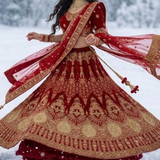 Bride twirling in red velvet bridal lehenga showing full embroidered skirt