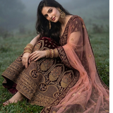 Model sitting on grass wearing Royal Wine Lehenga showcasing embroidered blush pink dupatta