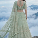Sage green lehenga back view showing embroidered blouse and flowing dupatta