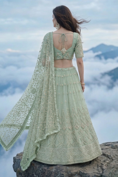 Sage green lehenga back view showing embroidered blouse and flowing dupatta