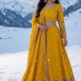 Woman in Sunshine Royale mustard embroidered lehenga set, snowy mountain backdrop