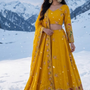 Woman in Sunshine Royale mustard embroidered lehenga set, snowy mountain backdrop