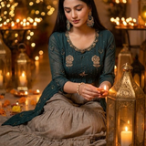 Teal kurta skirt set with grey flared skirt, seated lighting a diya