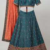 Close-up of teal lehenga blouse with rust orange dupatta detailing 