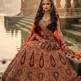 Bride in vintage zari bridal lehenga seated on temple steps by the water