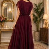 Wine maroon gown with sequin bodice and flowing pleated skirt, back pose