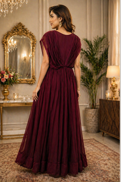 Wine maroon gown with sequin bodice and flowing pleated skirt, back pose